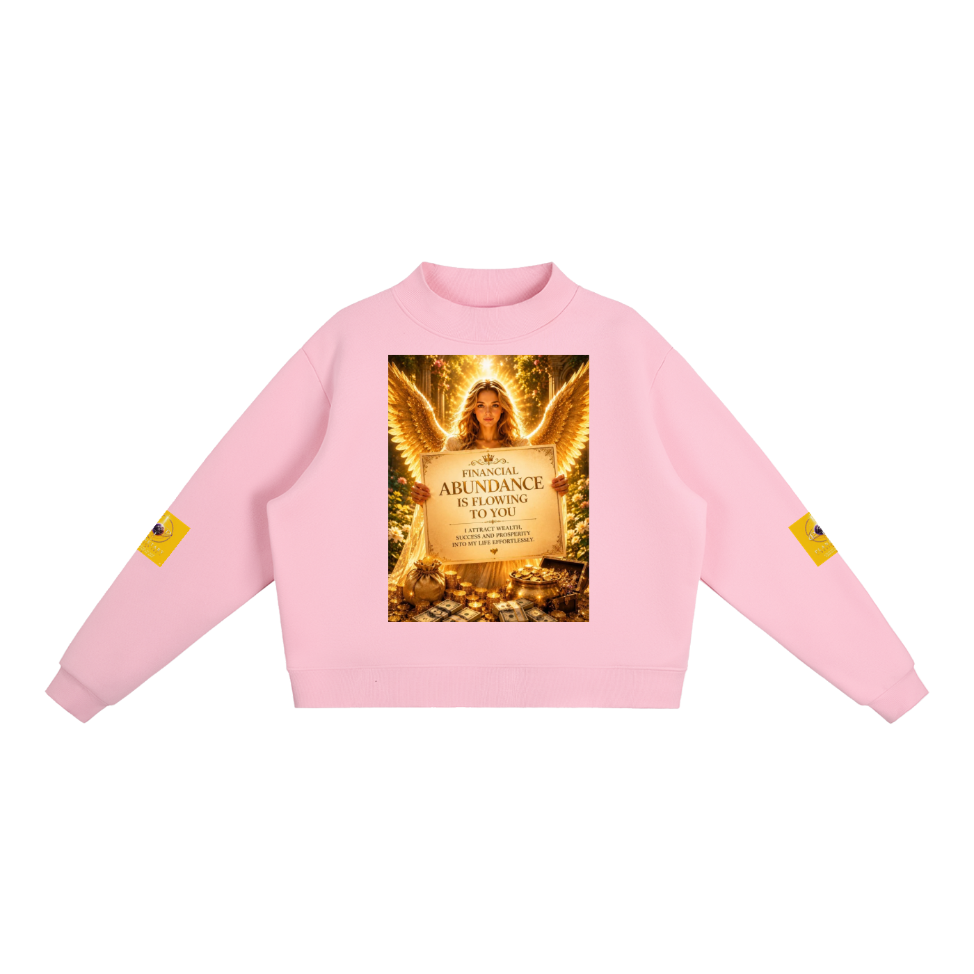 A light pink crewneck sweatshirt featuring a large graphic print on the front depicting an angel with wings and a sign that reads 'ABUNDANCE IS FLOWING TO YOU'. Each sleeve has a small yellow graphic patch, and the sweatshirt is displayed flat against a solid white background.
