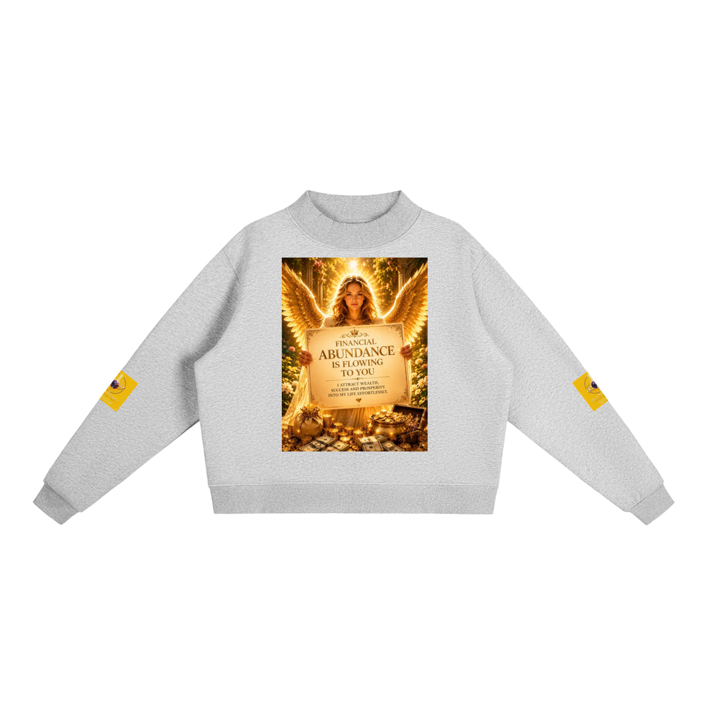 A light gray crewneck sweatshirt featuring a large graphic print on the front of an angel holding a sign that reads 'ABUNDANCE IS FLOWING IN YOU'. Each sleeve has a small yellow graphic patch, and the sweatshirt is displayed against a solid white background.