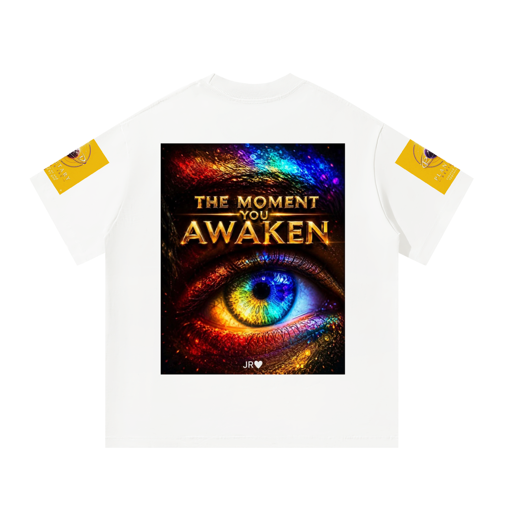 A white short-sleeve t-shirt with a large graphic print on the front showing a colorful cosmic eye and the text 'THE MOMENT YOU AWAKEN'. The sleeves feature small yellow patches with circular graphics, and a small 'JIR' logo is printed below the graphic.