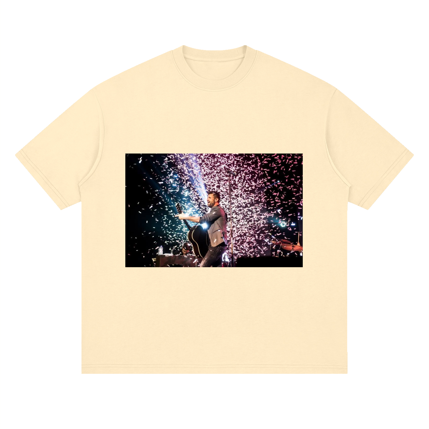 Beige t-shirt with a graphic of a person holding a sparkler against a fireworks display.