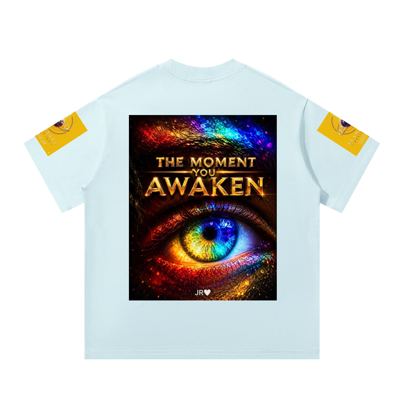 A light blue short-sleeve t-shirt shown flat against a white background, featuring a large graphic print on the back with a colorful cosmic eye and the text 'THE MOMENT YOU AWAKEN'. Each sleeve has a small yellow graphic patch.